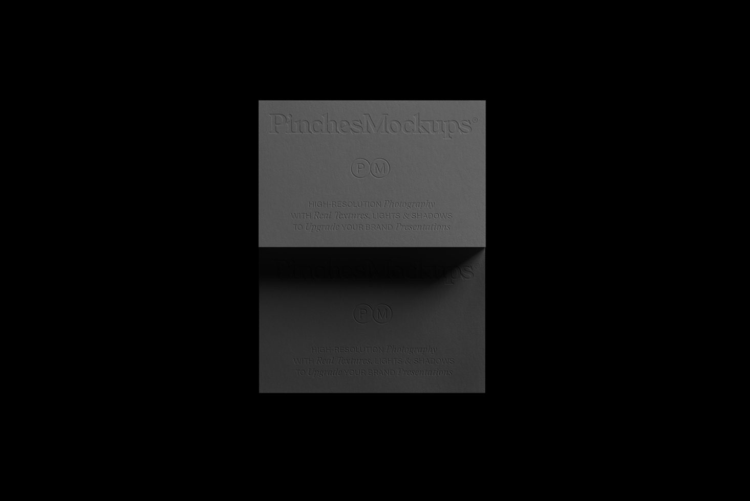 Elegant black cardstock presentation featuring embossed PinchMockups branding, showcasing real textures and lighting for high-quality mockups.